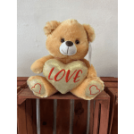 Teddy bear holding a heart with the word love