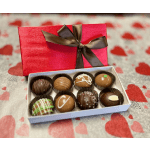Box of assorted chocolates with a red gift box and ribbon