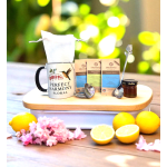 Gift set with a floral mug, tea packets, spoon, and jar on a tray