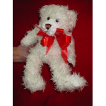 White teddy bear with a red ribbon on a red background