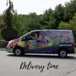 Flower delivery van with rose graphics and a driver visible in the window