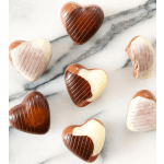 Assorted heart-shaped milk and white chocolates on a marble surface