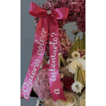 Pink floral arrangement with a large ribbon and white roses