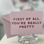 Pink greeting card in a clear glass holder with matching envelope