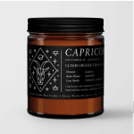 Amber candle in a black-lidded jar with a Capricorn label