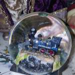 Miniature glittery train inside a clear snow globe