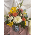 Mixed bouquet with yellow lilies, orange roses, and white chrysanthemums in a patterned vase