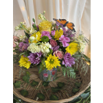 Colorful bouquet in a glass vase with a butterfly decoration