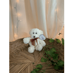White teddy bear with a brown ribbon sitting on a woven tray