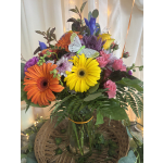 Colorful mixed bouquet in a glass vase with a butterfly decoration