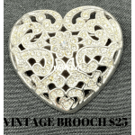 Heart-shaped jeweled brooch on dark fabric