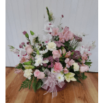 Pink and white mixed flower arrangement in a low basket with a ribbon bow