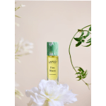A perfume bottle labeled LAFCO New York First Bloom with white flowers around it.