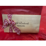 Gold chocolate gift box with a red heart-pattern ribbon