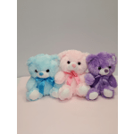 Three pastel teddy bears with ribbons sitting side by side