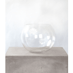 Empty round clear glass bowl vase on a concrete block