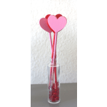 Clear bottle filled with red gems holding pink and red wooden heart sticks
