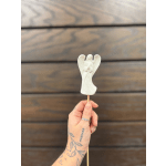 Hand holding a white angel-shaped lollipop on a stick