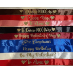 Stack of satin gift ribbons with gold lettering and hearts