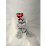 Gray plush teddy bear holding a red heart balloon