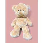 Beige teddy bear plush toy on a pink background