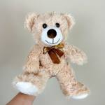 Plush teddy bear with a brown ribbon bow