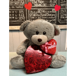 Gray teddy bear holding red heart gifts