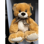 A plush teddy bear with a plaid bow sits on a shelf.