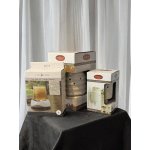 Three boxed candle warmers on a draped table