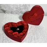Heart-shaped red gift box with red roses and a ring inside