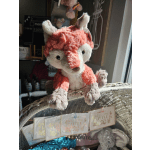 Plush fox toy sitting on a wicker basket with baby cards below