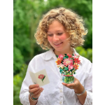 Person holding a floral pop-up bouquet card and a matching note card outdoors