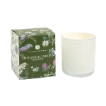 White glass candle next to a green botanical-printed box labeled Botanical Verde.