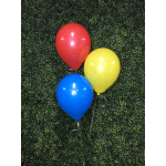 Three colorful balloons against a green hedge wall
