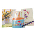 Three greeting cards with floral designs and birthday candles, plus a pen