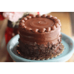 Small round chocolate cake on a blue cake stand