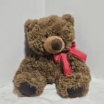 Brown teddy bear with a red ribbon bow