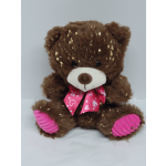 Brown teddy bear with a pink heart-patterned bow and pink paws