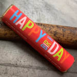 Red candy bar wrapper with colorful "Happy Birthday" text