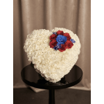 Heart-shaped white floral arrangement with red and blue roses