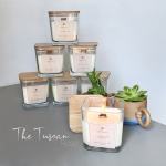Assorted square candles and two small potted succulents on a gray surface
