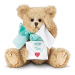 Teddy bear holding a "Miss You" card with a ribbon