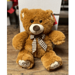 Brown teddy bear with a plaid bow sitting on a wooden surface