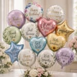 Assorted message balloons in pastel colors with a small flower base.