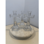 Three clear glass cross-shaped ornaments on a round white base