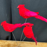 Three red fabric birds on thin wire stems