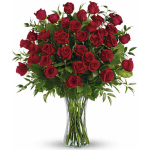 Red roses arranged in a clear glass vase