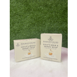 Two boxed bars of goat's milk and honey soap on a white surface