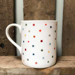 White ceramic mug with multicolored polka dots