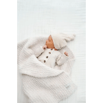 Sleeping baby in a white knit outfit and hat, wrapped in a fluffy white blanket